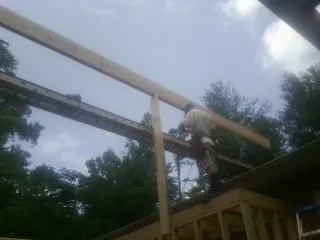 Carpenter setting a ridge beam over a new addition frame — Ice Dam Removal by Roofing Brothers in Victory Mills