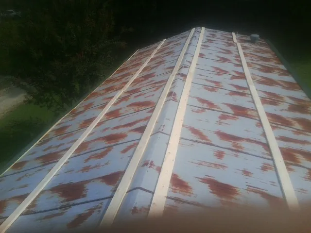 Rusted metal roof panels with new wood purlins before replacement — Storm Damage Roof Repair in Victory Mills by Roofing Brothers