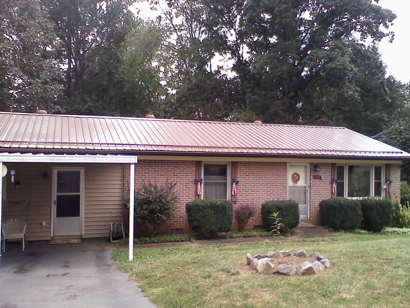 Bronze metal roof and carport on a brick ranch home — Roof Repair work by our crew in Victory Mills